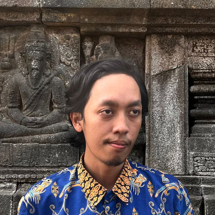 Portrait of Lutfi Azis in front of a Prambanan temple wall.